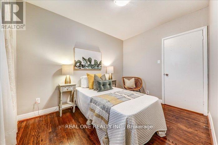 A bedroom with a bed, a chair, and a nightstand.