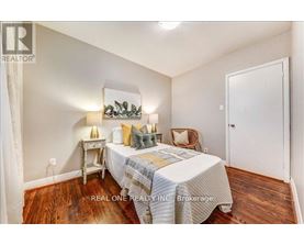 A bedroom with a bed, a chair, and a nightstand.
