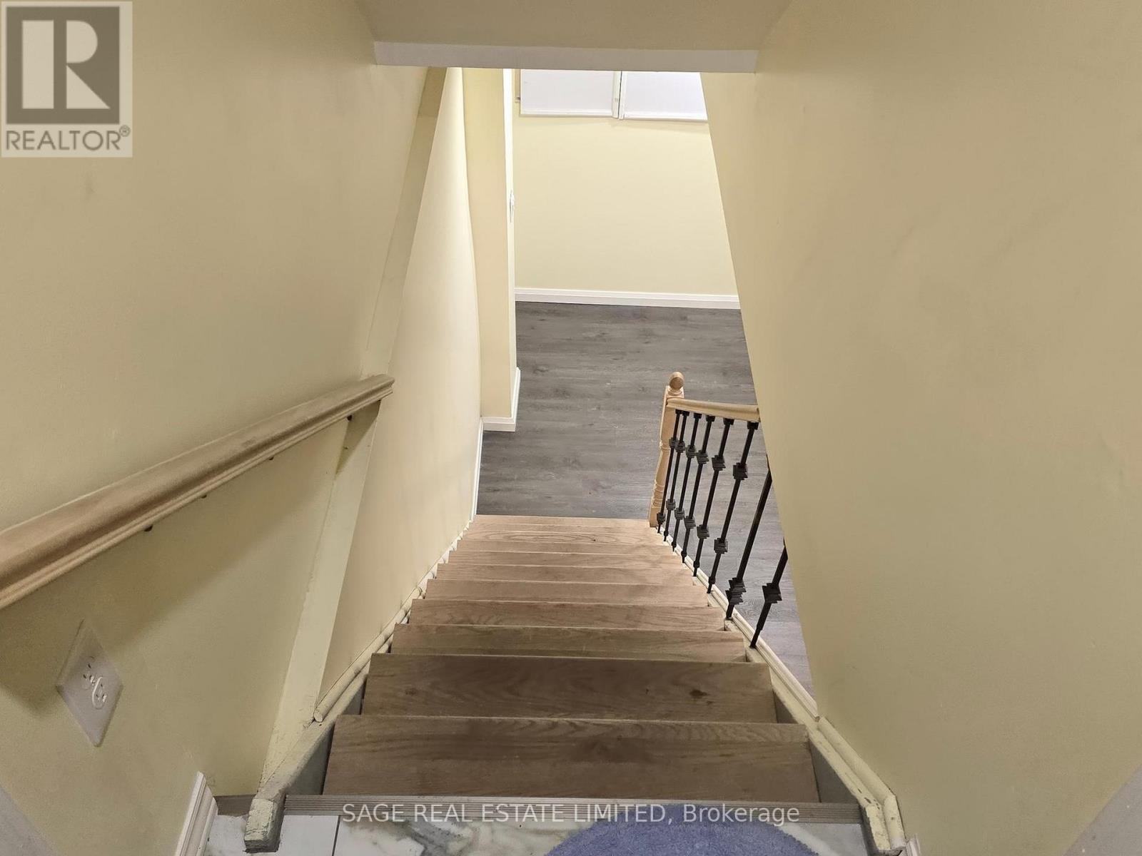 A staircase with a wooden handrail and a landing.