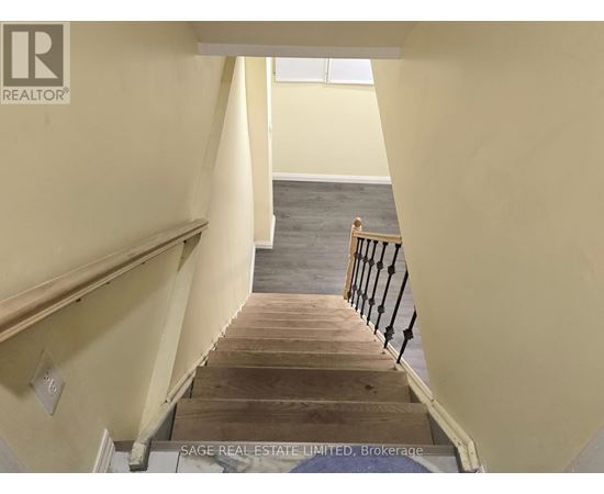 A staircase with a wooden handrail and a landing.