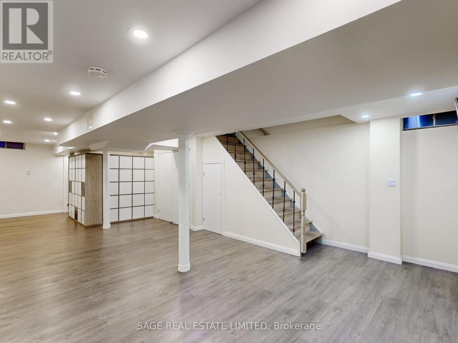 A spacious room with a staircase and a wooden floor.