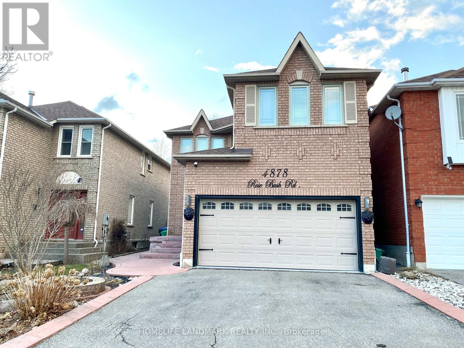 A brick house with a white garage door and the number 1783 on the brick wall.