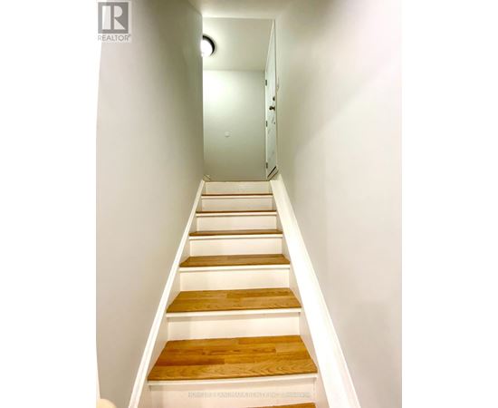A set of stairs with white risers and wooden treads.