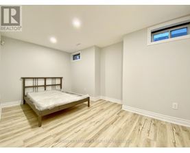A bedroom with a bed, wooden floors, and a window.