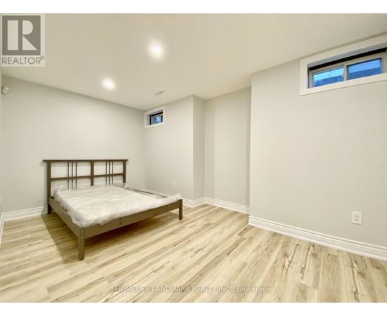 A bedroom with a bed, wooden floors, and a window.