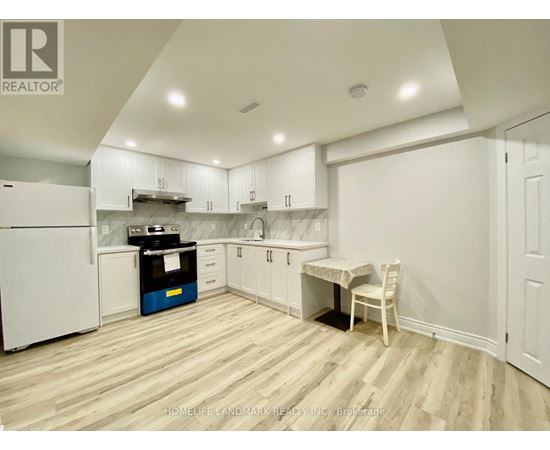 A kitchen with white cabinets and a wooden floor.