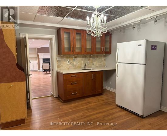 A kitchen with a white refrigerator and wooden cabinets.