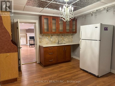 A kitchen with a white refrigerator and wooden cabinets.
