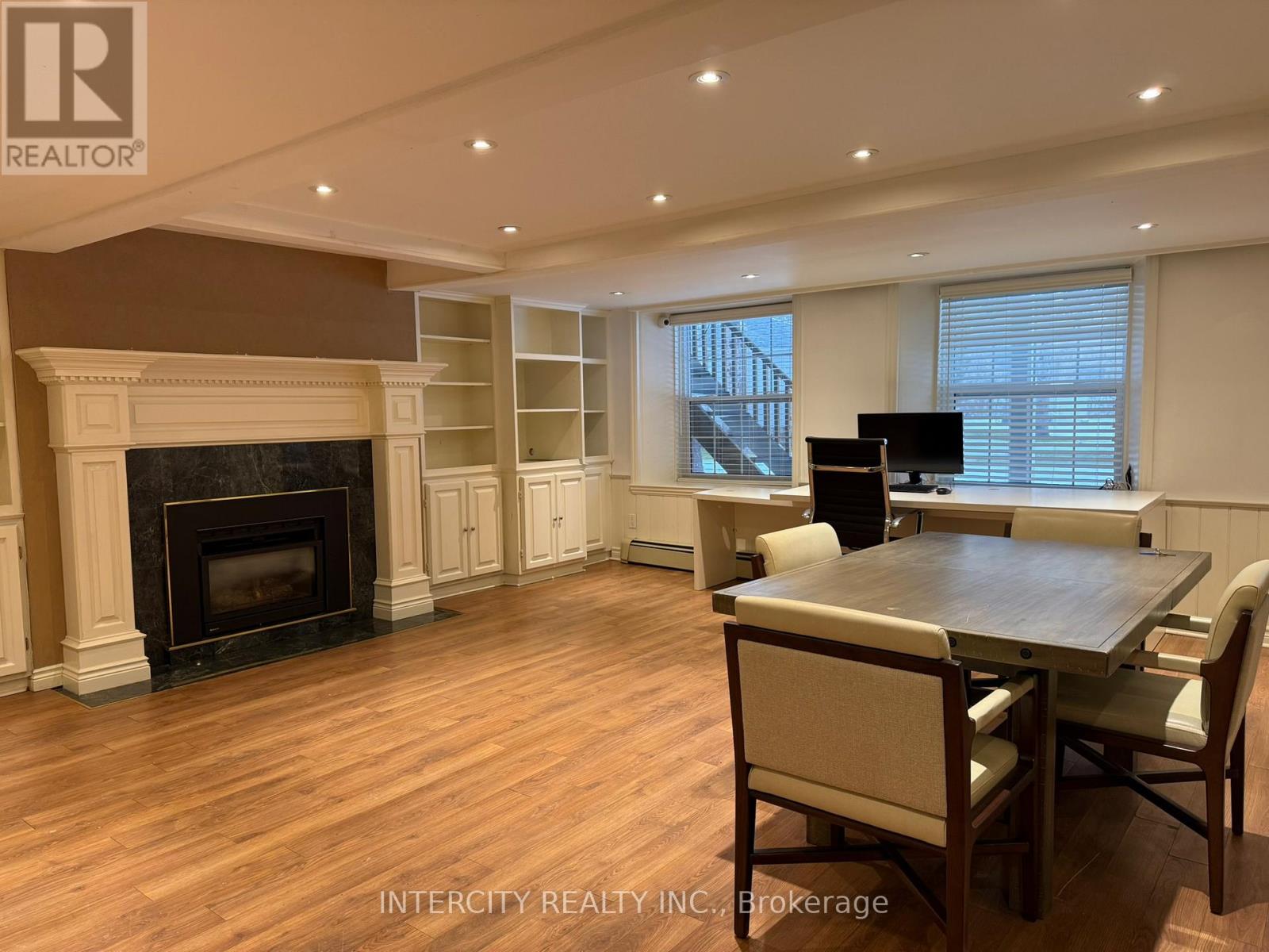 A living room with a fireplace and a dining table.