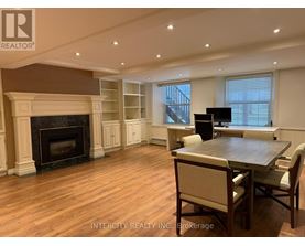 A living room with a fireplace and a dining table.