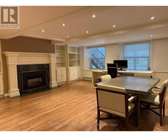 A living room with a fireplace and a dining table.