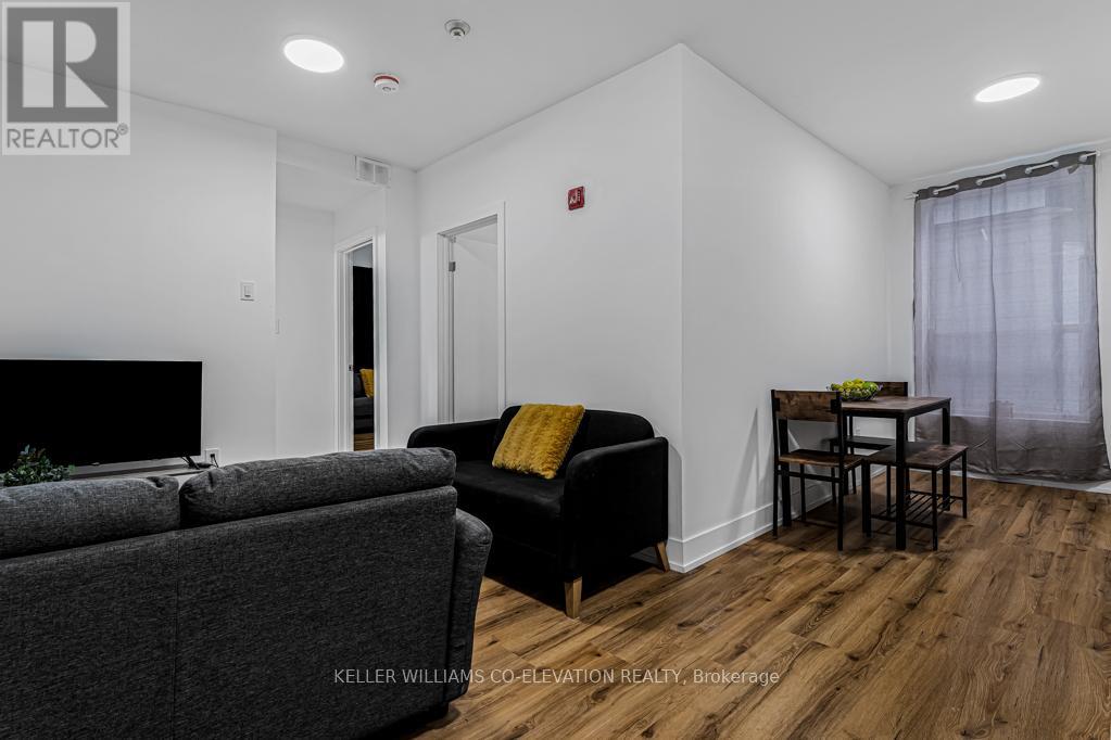 A living room with a grey couch and a black chair.