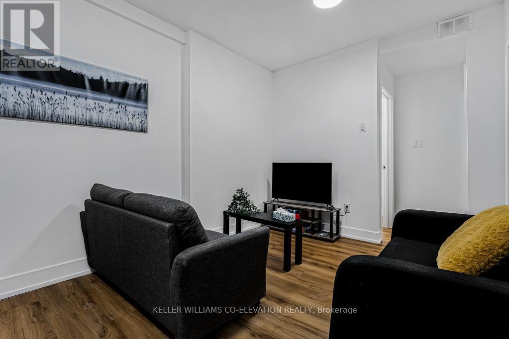 A living room with a grey couch, a black coffee table, and a television.