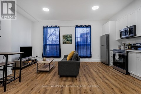 A living room with a grey couch and a wooden floor.