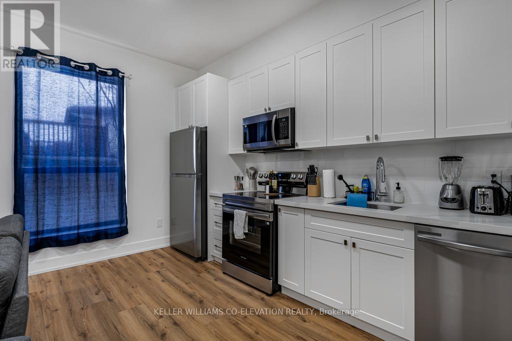 A kitchen with white cabinets and a wooden floor.
