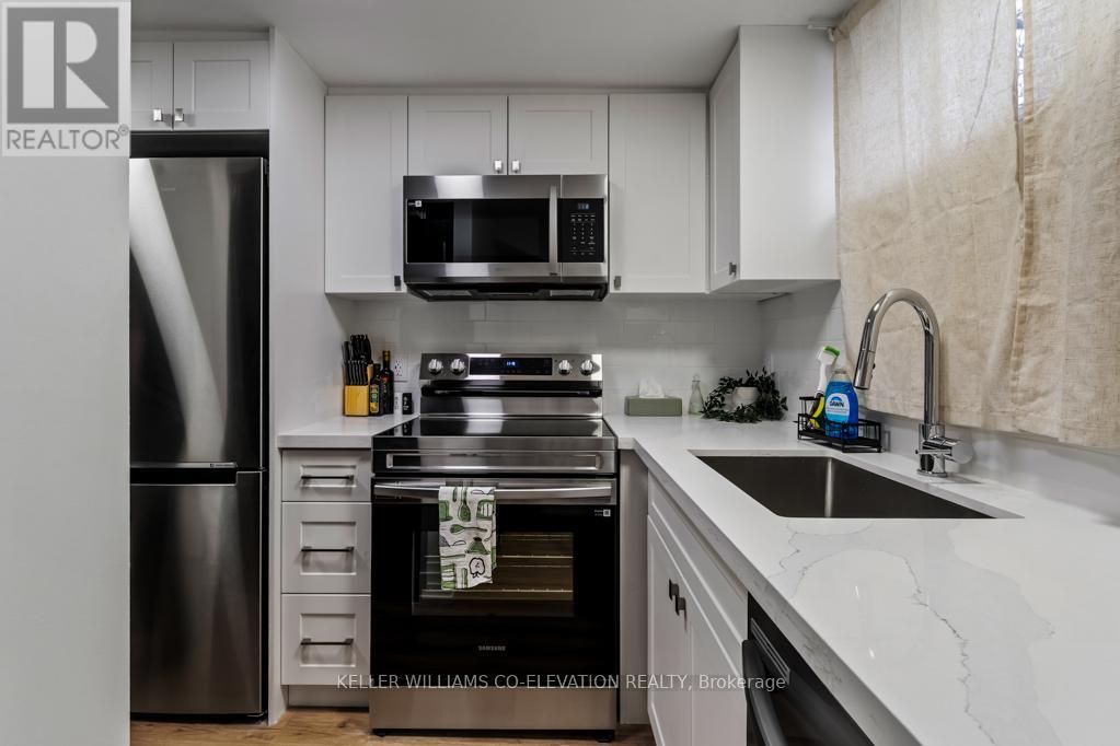 A modern kitchen with a stainless steel refrigerator, oven, and sink.