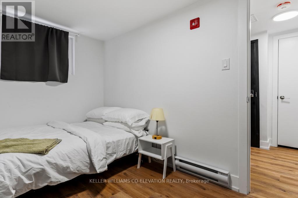A bedroom with a bed, nightstand, and lamp.