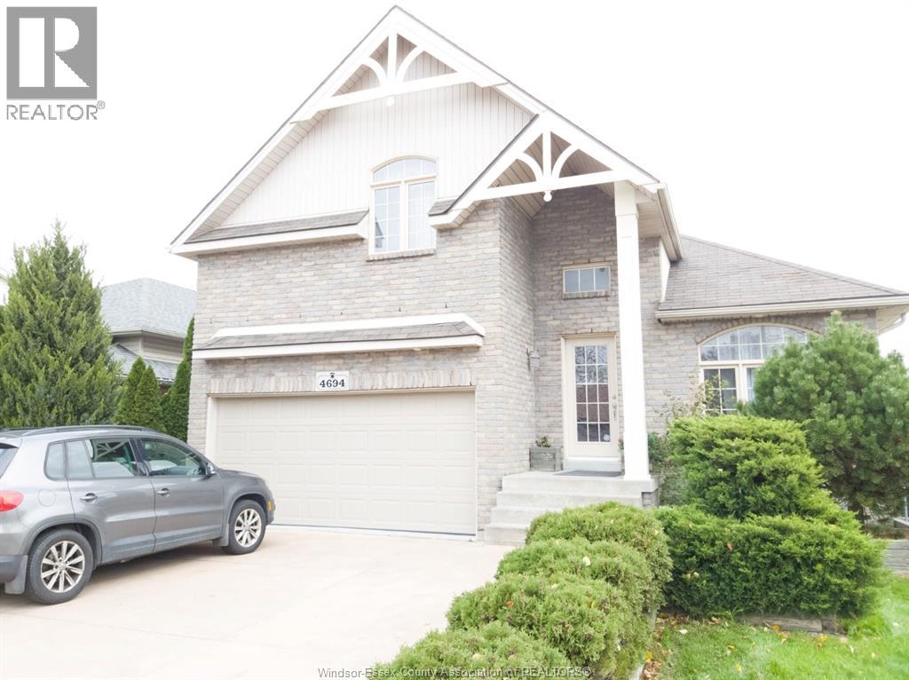 A house with a grey car in front of it.