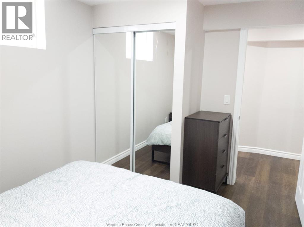 A bedroom with a bed, a dresser and a mirror.