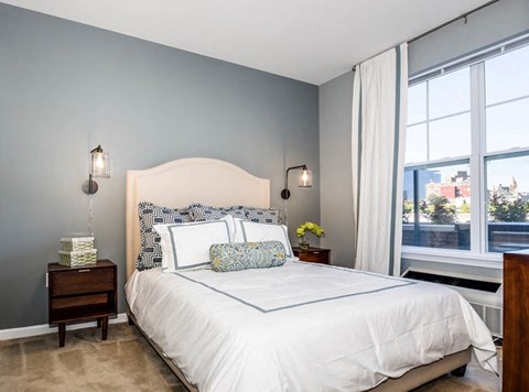 a bedroom with a bed and two windows