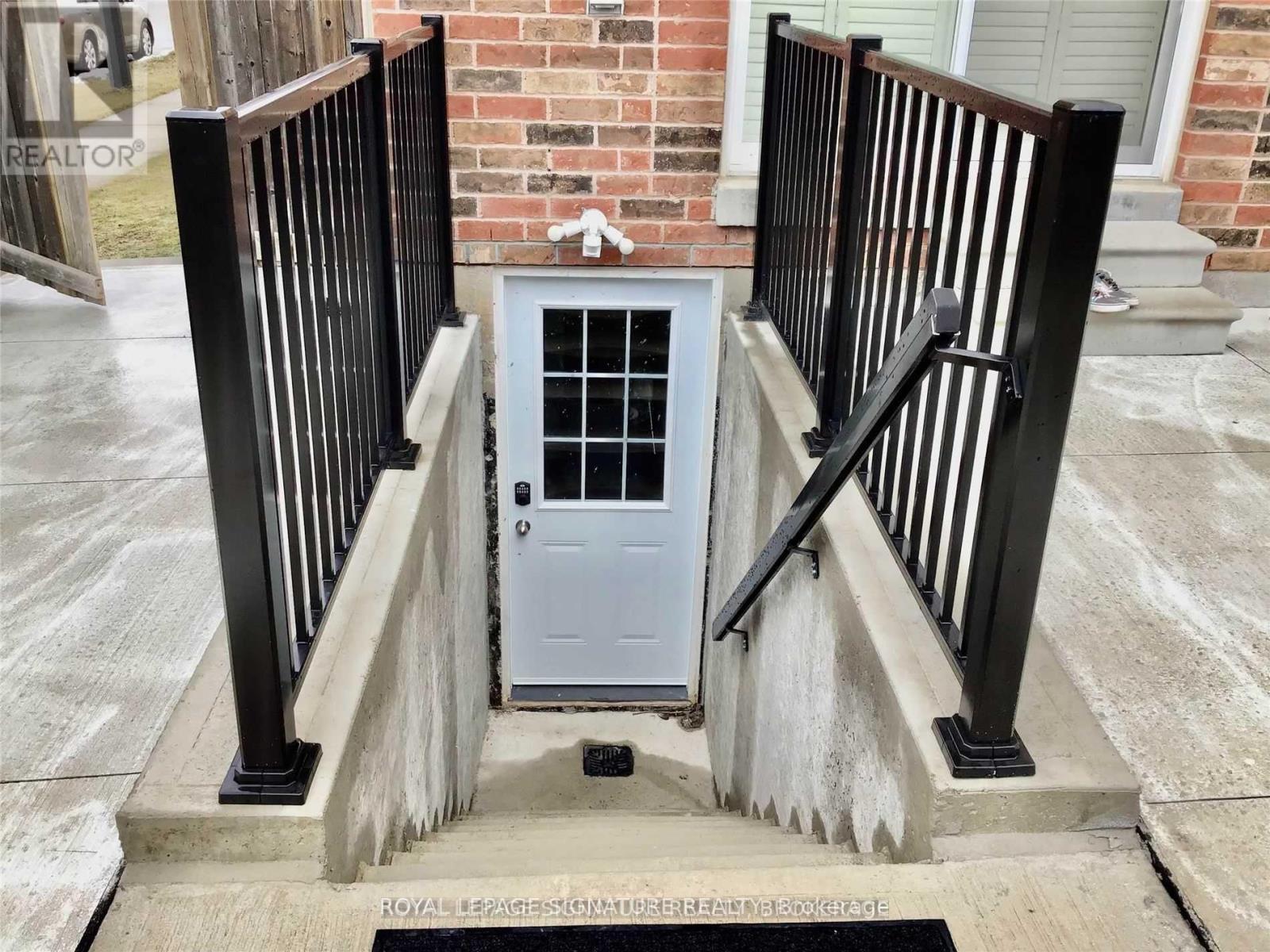 A white door with a screen is set in a black railing.