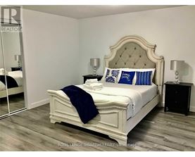 A bedroom with a white bed and blue pillows.