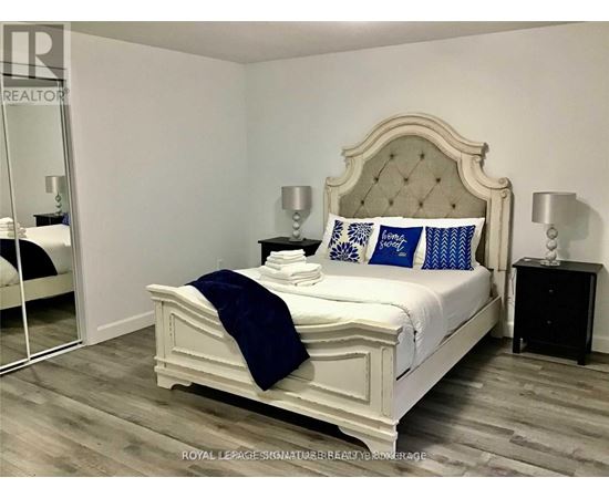 A bedroom with a white bed and blue pillows.