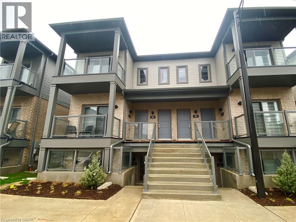 A modern two-story residential building with a staircase leading to the entrance.