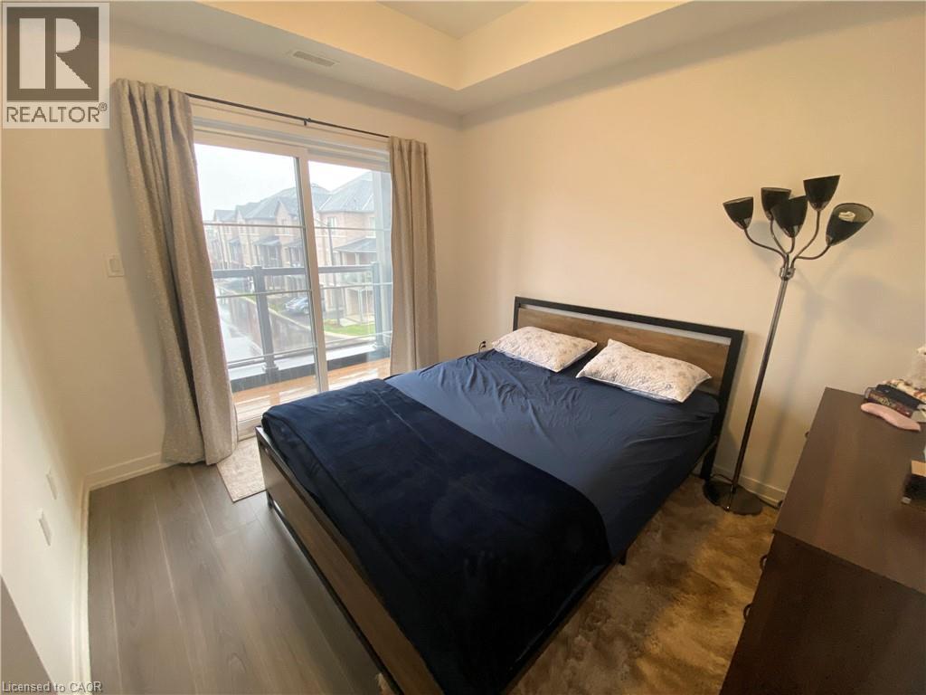 A bedroom with a large bed and a window with curtains.