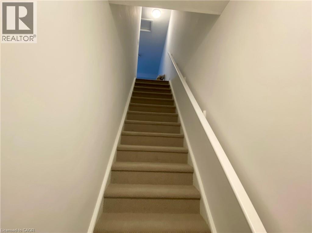 A staircase with beige carpeted steps and white railings.