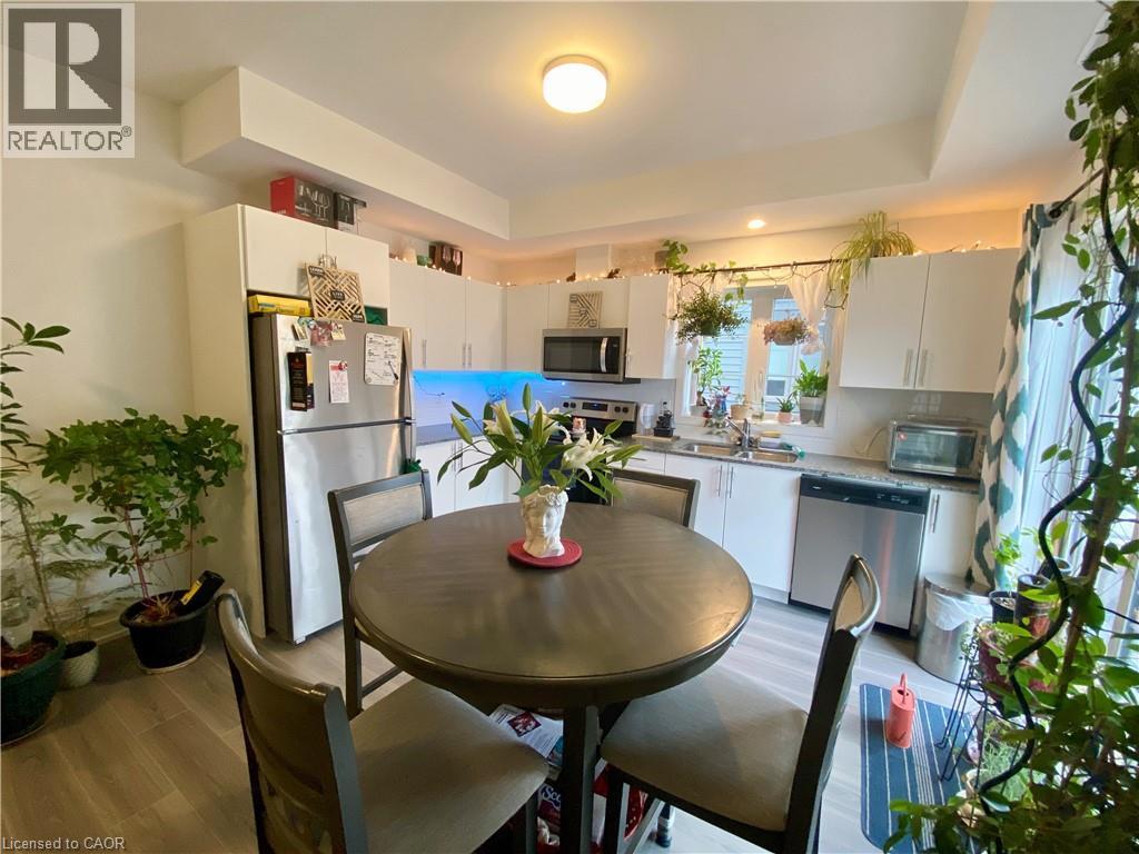 A kitchen with a table and chairs in the foreground and a refrigerator in the background.