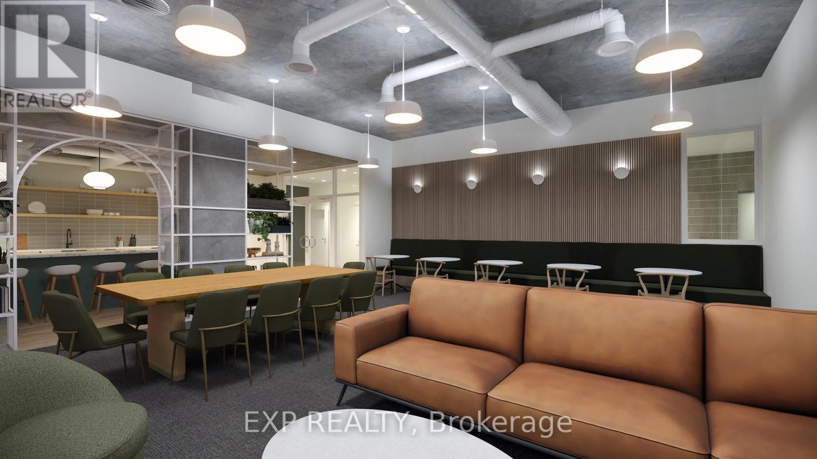 A modern office space with a long brown couch and a glass wall.