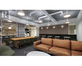 A modern office space with a long brown couch and a glass wall.
