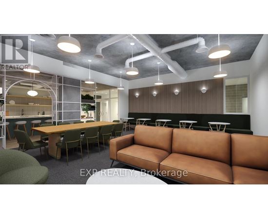 A modern office space with a long brown couch and a glass wall.