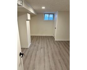 A room with a window and wooden flooring.