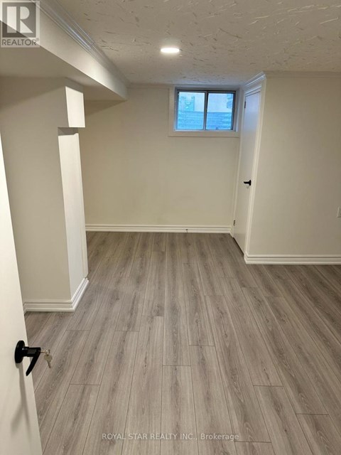 A room with a window and wooden flooring.