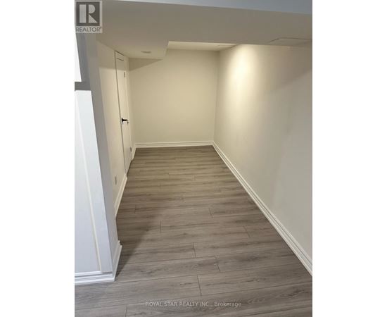 A hallway with wood flooring and white walls.