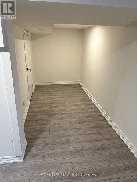 A hallway with wood flooring and white walls.