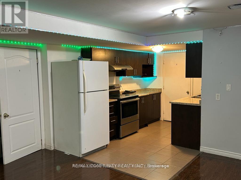 A kitchen with a white refrigerator and wooden cabinets.