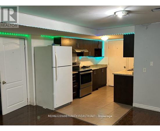 A kitchen with a white refrigerator and wooden cabinets.