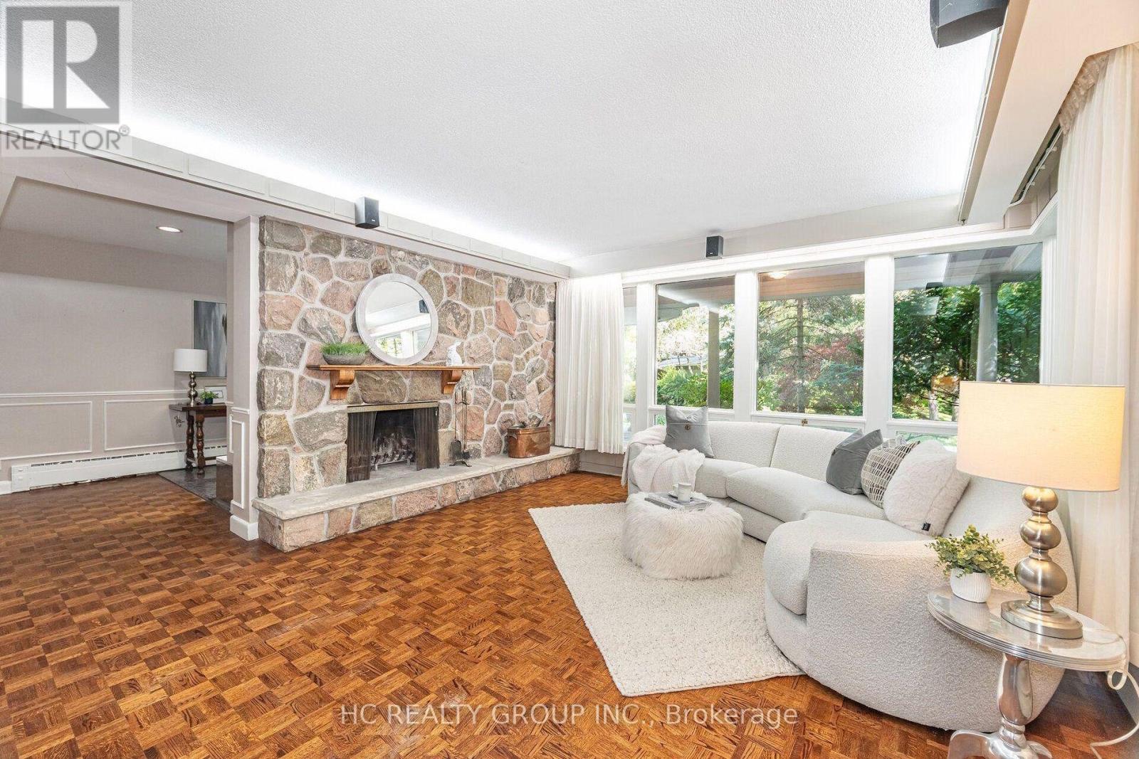 A living room with a stone fireplace and a grey sofa.