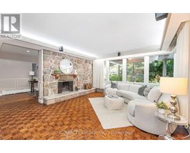 A living room with a stone fireplace and a grey sofa.