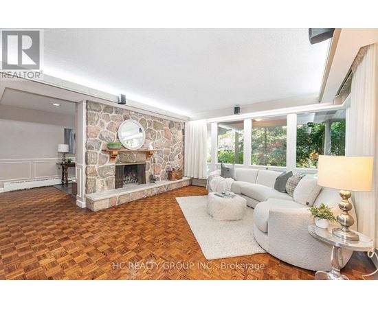 A living room with a stone fireplace and a grey sofa.