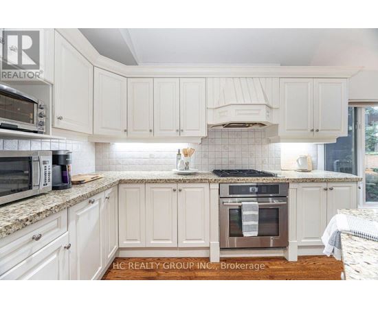 A kitchen with white cabinets and a tile backsplash.