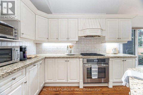 A kitchen with white cabinets and a tile backsplash.