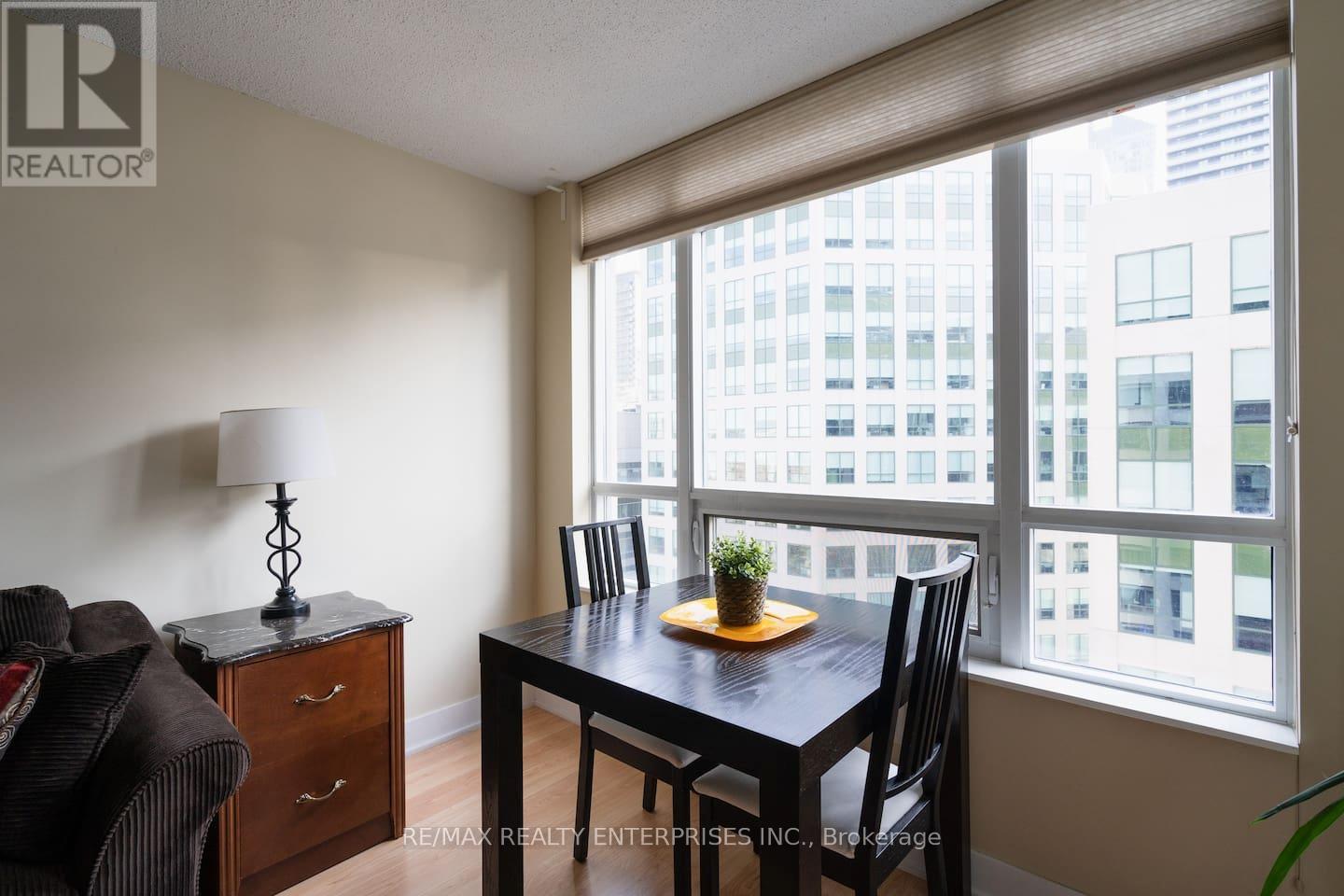 A dining room with a table and chairs and a view of a city.