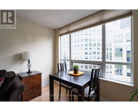 A dining room with a table and chairs and a view of a city.