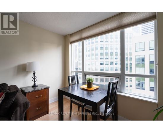 A dining room with a table and chairs and a view of a city.