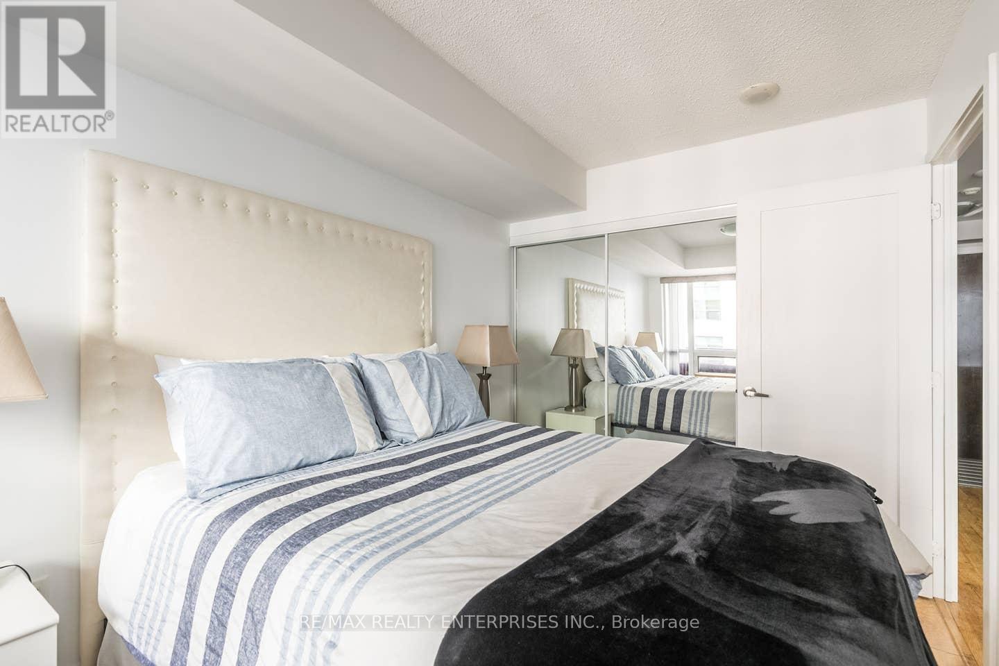 A bedroom with a large bed and a mirror on the wall.