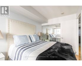 A bedroom with a large bed and a mirror on the wall.